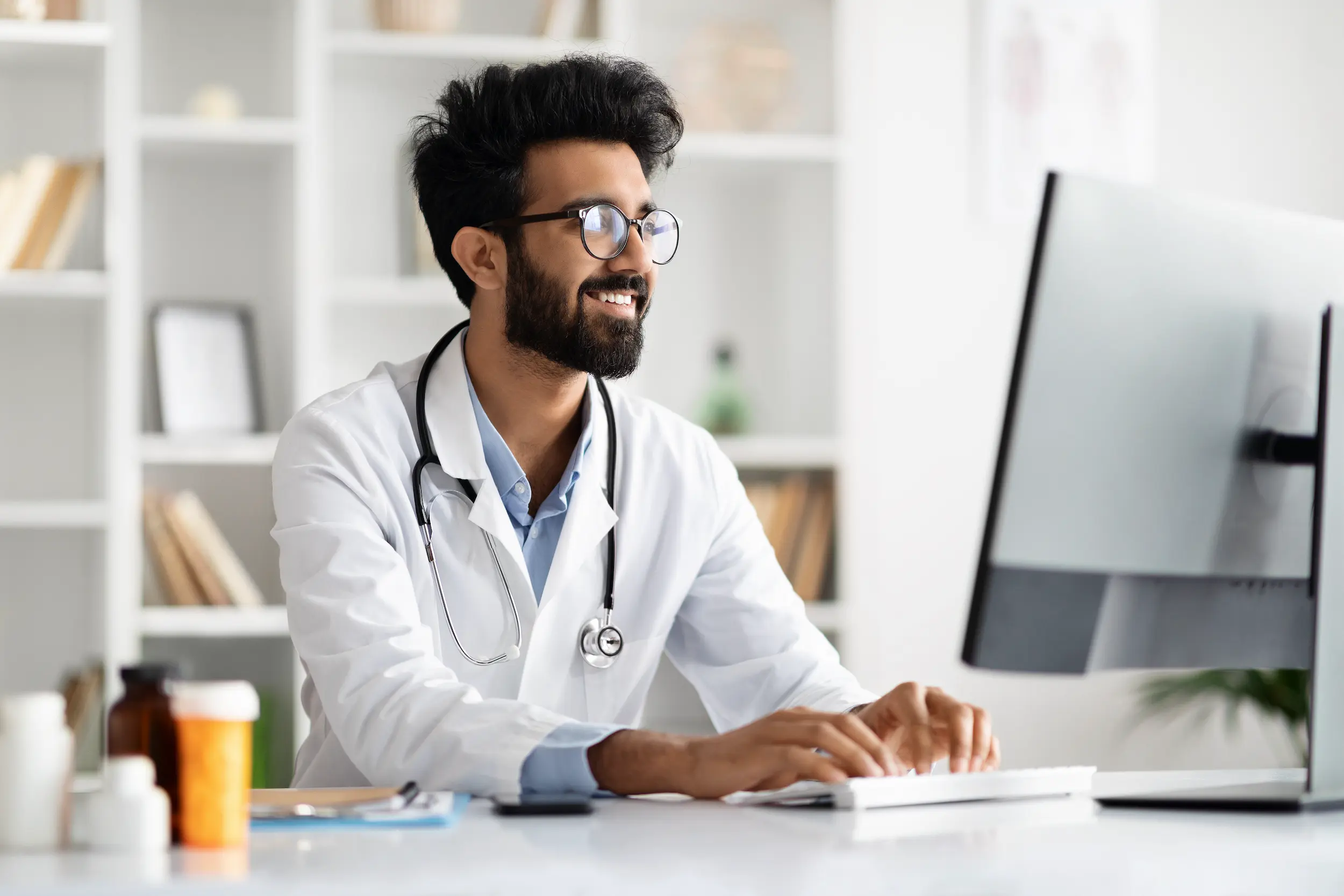 smiling doctor working at computer in office 2026 03 24 02 06 16 utc